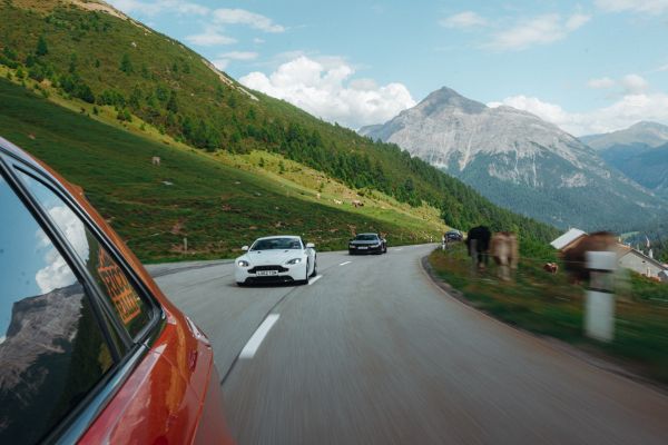 a rolling shot from an audi rs of an aston martin in switzerland