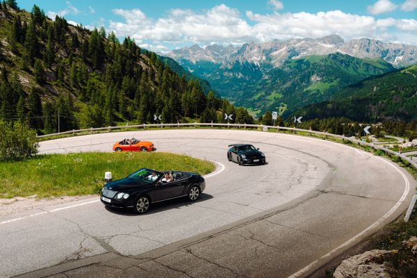 rico rally cars round a bend in Austria with mountains in the background